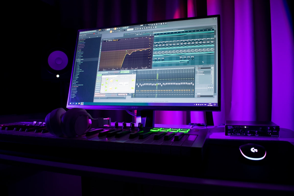 Music production setup with computer and equipment.