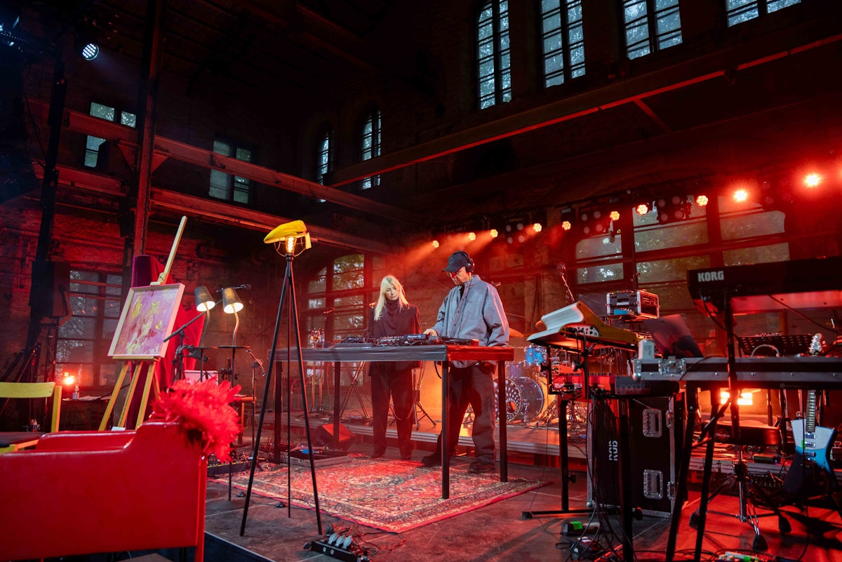 Musicians performing with keyboards on a stage.