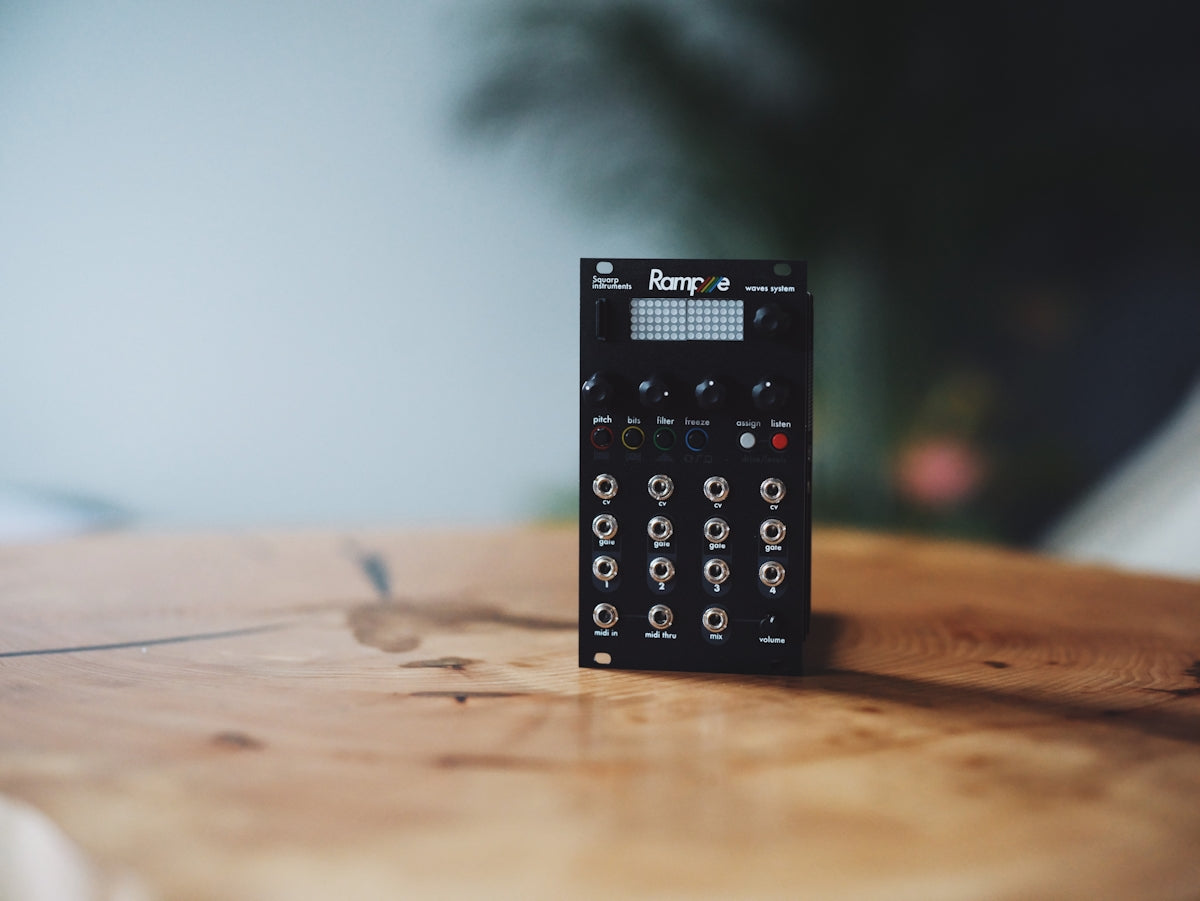 A small black electronic device on a wooden table.